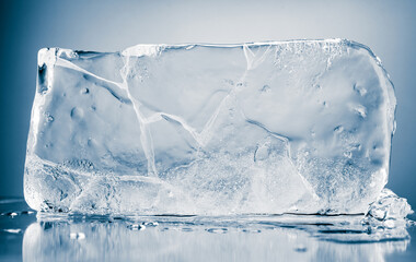 A textured block of transparent ice on a blue background.