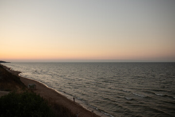 The strip between the coast and the sea. The sea at sunset. The waves are creeping ashore. The landscape of the sea.