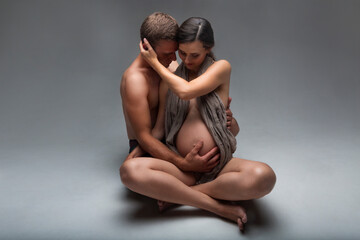 Young man and pregnant woman in studio