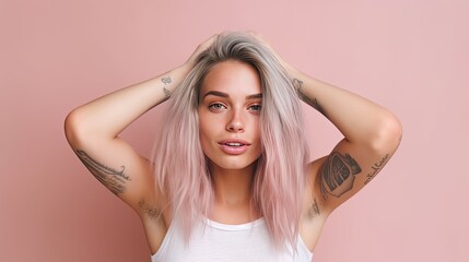 Fototapeta premium Portrait of a pleasant-looking casual woman with long hair, pink tips, tattoos on her arms, dressed in a white casual t-shirt.