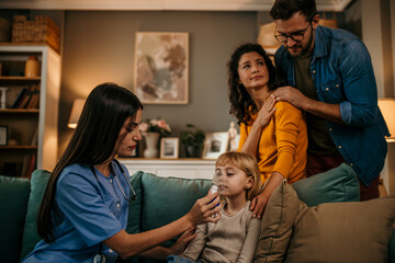Parents watching attentively as a home nurse administers a nebulizer to their daughter