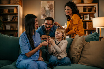 Mom and dad watching their playful daughter pretend to be a nurse, checking a home nurse with a stethoscope - obrazy, fototapety, plakaty