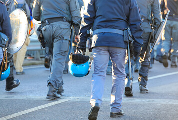 policemen in uniform with riot gear during the protest demonstration with helmets and shields