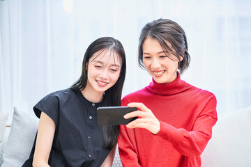 スマートフォンの画面を見ている女性達