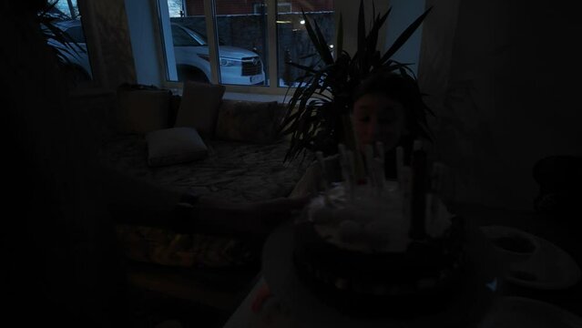 Birthday party. Girl blowing the candles and celebrating birthday with family at home
