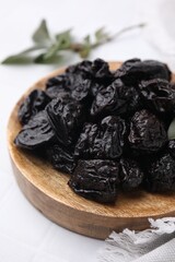 Sweet dried prunes on white table, closeup