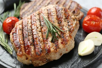 Delicious grilled pork steaks with spices on table, closeup
