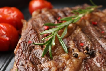Delicious grilled beef steak, tomatoes and rosemary in frying pan, closeup