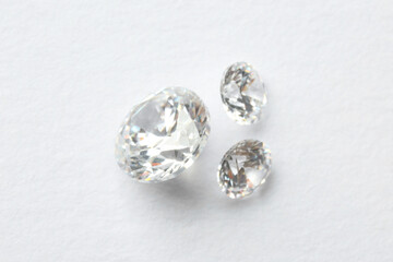 Beautiful shiny diamonds on white background, flat lay