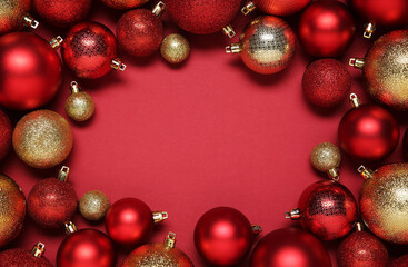 Frame of beautiful Christmas balls on red background, top view. Space for text