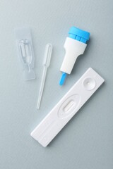 Disposable express test kit on light blue background, flat lay