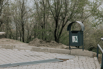 Urban space need regeneration: sagging curb, construction sand, crooked paving stones, storm drain,...