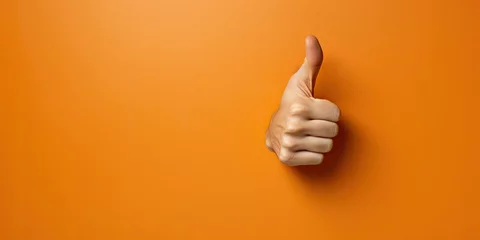 Foto op Aluminium An arm sticks out of an orange wall and shows a thumbs up © Creative Canvas