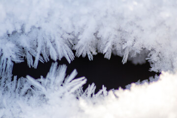 Ice crystals macro in close-up view shows beautiful ice structures of frozen water with spikey crystals and elegant snowflakes after winter snowfall in arctic climate with cold temperatures crackling