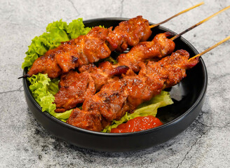 grilled meat on skewers or thit nuong xien que witth lettuce leaf served in dish isolated on grey background top view of singapore seafood