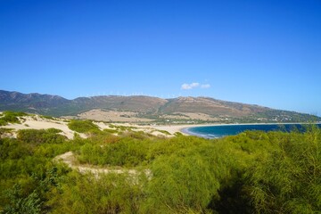 Fototapeta na wymiar view of the beautiful coastline at the Punta Paloma beach with dunes and mountains near Valdevaqueros, Tarifa, Andalusia, province of Cádiz, Spain 