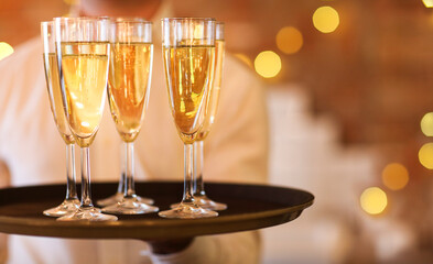 Champagne glasses on tray in bright lights