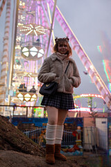 Obraz na płótnie Canvas young cosplay woman on fun fare and Ferris wheel with magic winter lights