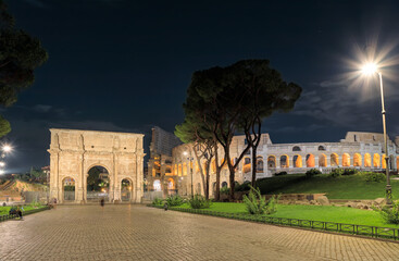 Night cityscape of Rome: view of Colosseum and Arch of Constantine, Italy.