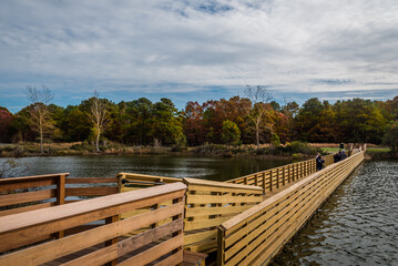 Fototapeta na wymiar wooden floating bridge over river in the park