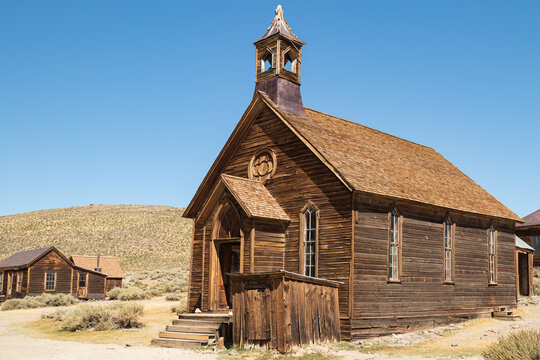 Deserted Brodie Ghost Town Chruch in the arid desert landscape of California with a cloudless blue sky and no people. 