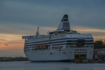 large cruise ship loading at the pier at sunset
