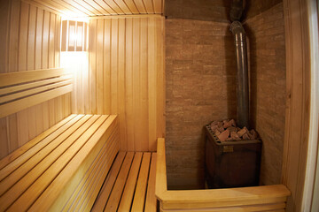 Interior of Finnish sauna, classic wooden sauna with hot steam. Russian bathroom.