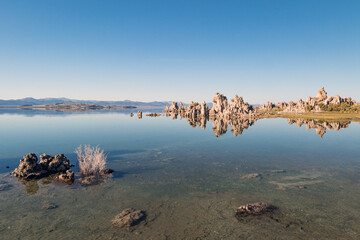 Desert landscape of Mono Lake reflecting the surrounding blue sky and Tufa mineral rock formations in California, USA