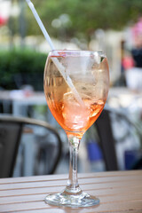 close up of drink glasses with ramazzotti rosato ice on a bistro table with blurred square in the background
