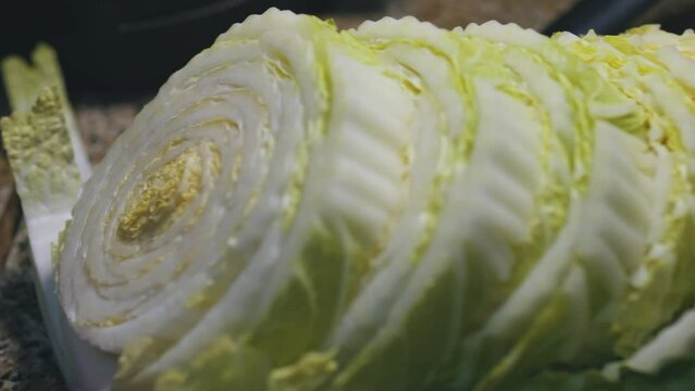 Chinese napa cabbage slices on a red cutting board. Close up.
