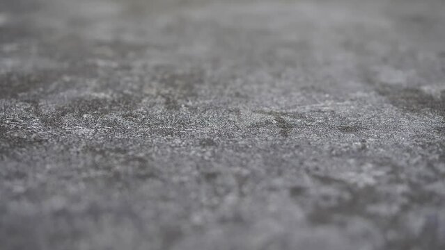 Selective focus close up concrete texture. Paper or non-woven wallpaper with imitation of concrete plaster in a loft style. Refocusing on gray and silver textures. Focus movement