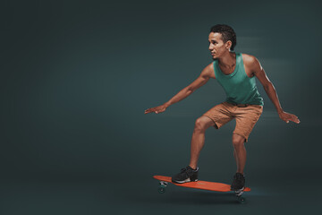 Fototapeta na wymiar Studio shot of a young man riding a skateboard isolated on dark background