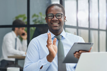 a man at a workplace at a table in front of a computer uses a tablet