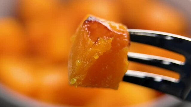 Baked pumpkin slice on a fork. Roasted butternut squash. Healthy vegan food. Macro shot