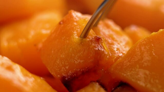 Sweet baked vegetable butternut squash pumpkin in the process of lunch. Macro shot