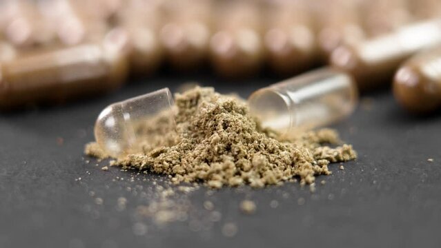 Nutritional supplement vitamin capsule with spilled powder close up. Alternative herbal treatment. Rotation