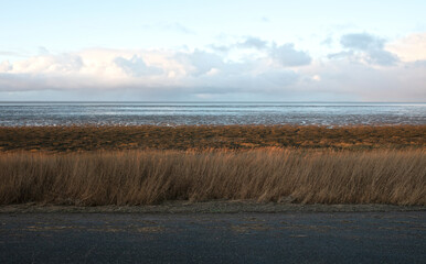 Dutch wide landscape with dike and winter sky, Waddensea