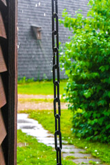 Chain in the rain at wooden house in Germany.