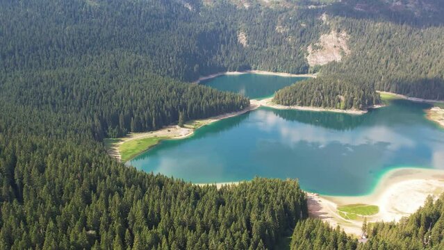 Aerial view of Black Lake in Durmitor National Park, Montenegro. Mountain lake Crno Jezero in Zabljak is attraction of Monenegro. Sunny summer day.
