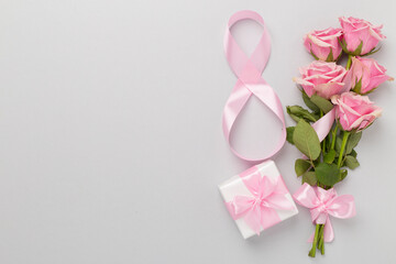 Composition with pink roses, gift box and eight made of ribbon on color background, top view....