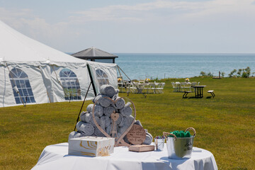 Outdoor tent wedding trend. A stand with a welcome sign and blankets for guests. 