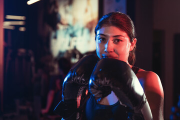 Focused Female Boxer Training Alone in Atmospheric Gym
