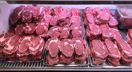 Ribeye steaks aligned in a butcher's meat case