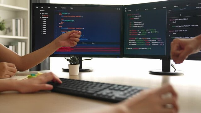 Slow motion back end software developer engineer for computer programming working together on debugging writing computing code, solving complex algorithms display on monitor in office. Burgeoning