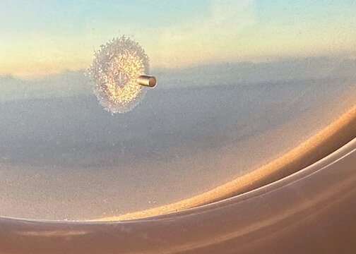 Frost around the ventilation hole in an airplane window