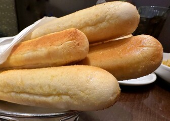 Four breadsticks wrapped in a white paper towel arranged for choosing