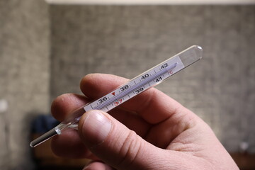 Temperature measurement. Illness and cold. The thermometer is held in the hand.