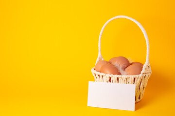 Easter holiday card with eggs in straw basket on yellow background with price list or business...