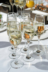 Champagne glasses on the table, beautiful lights. Luxury catering, set festive table.