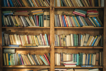 Blurred Bookshelf With Old Books Is Presented, Toned In Brown Colors To Evoke Vintage And Nostalgic Ambiance. Essence Of Antiquarian Literature And Aged Pages, Creating Warm And Classical Setting